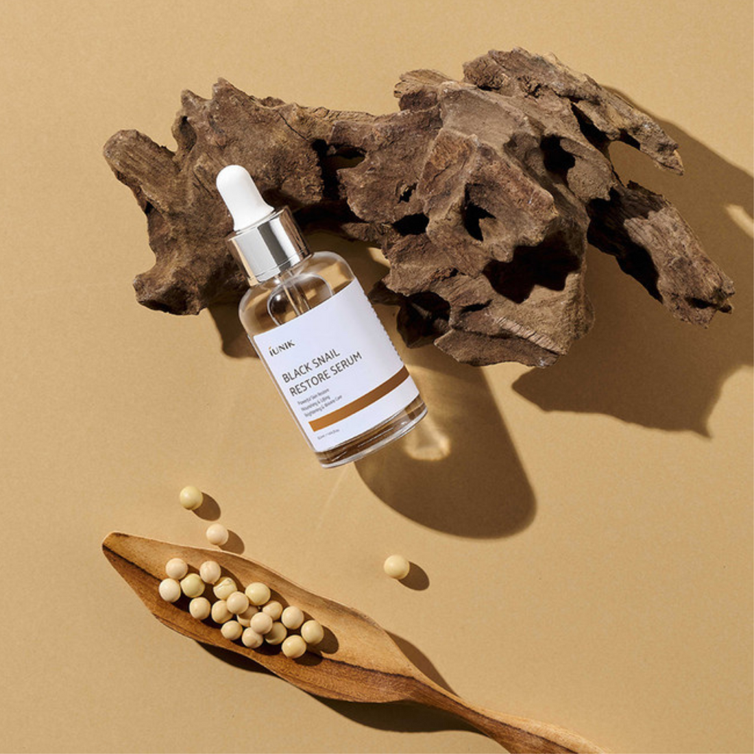 IUNIK Black Snail Restore Serum (50ml) product shot with nature elements